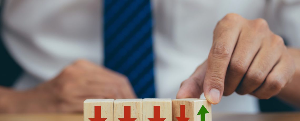 2 - businessman-hand-flipping-one-many-cubes-with-downward-facing-arrows-find-one-pointing-upward
