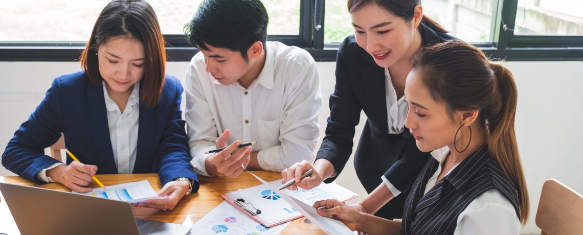 Group of young asian entrepreneurs in business casual working together on setting up new business