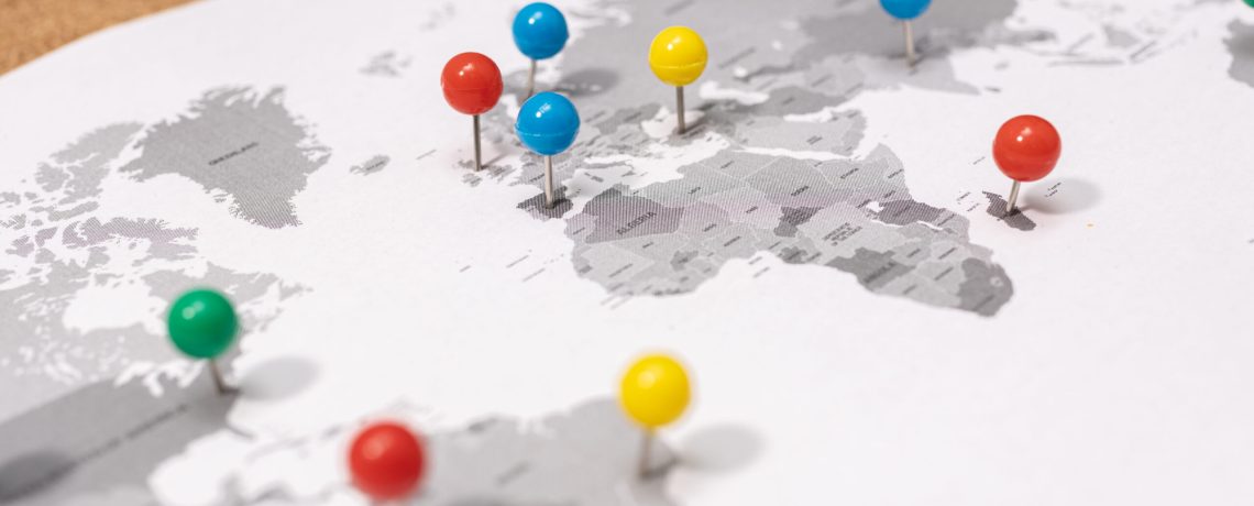 Close up of Pushpins on world map on Corkboard. Travel destination concept