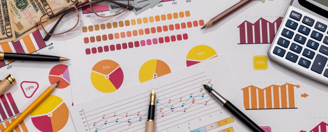 American dollars on business graphs with pen and calculator