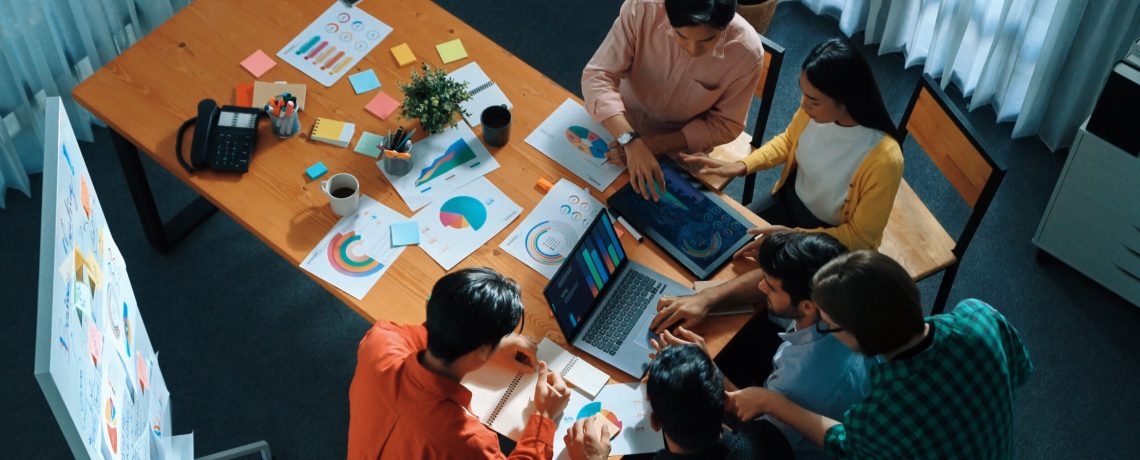Top down view of business team putting hand together while discussing about Ux Ui design for mobile phone at boardroom. Close up of marketing team making stack of hand and clapping hand. Convocation.